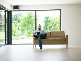 Image showing man on sofa using tablet computer