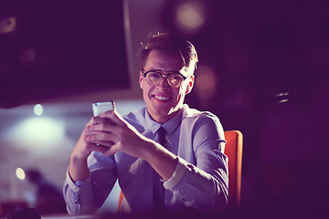 Image showing man using mobile phone in dark office