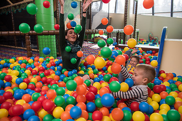 Image showing Young mom with her kids in a children\'s playroom