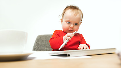 Image showing Happy child baby girl toddler sitting with keyboard of computer isolated on a white background