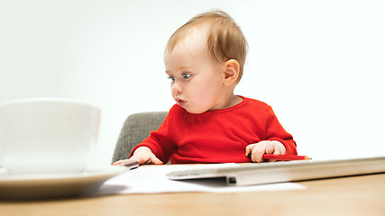 Image showing Happy child baby girl toddler sitting with keyboard of computer isolated on a white background