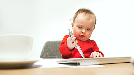 Image showing Happy child baby girl toddler sitting with keyboard of computer isolated on a white background