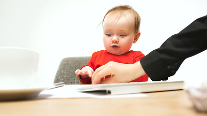 Image showing Happy child baby girl toddler sitting with keyboard of computer isolated on a white background