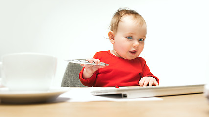 Image showing Happy child baby girl toddler sitting with keyboard of computer isolated on a white background