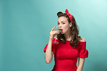 Image showing Beautiful young woman with pinup make-up and hairstyle. Studio shot on white background