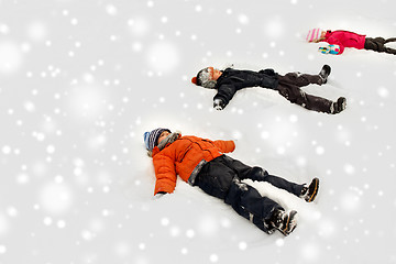 Image showing happy little kids making snow angels in winter