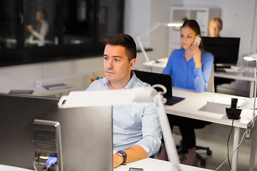 Image showing man with computer working at night office