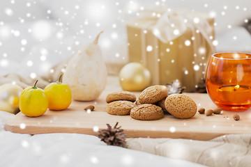 Image showing cookies, lemons, candle and christmas gift at home