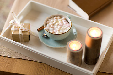 Image showing hot chocolate, christmas gift and candles on table