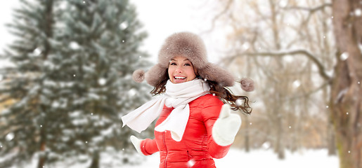 Image showing happy woman in fur hat over winter forest