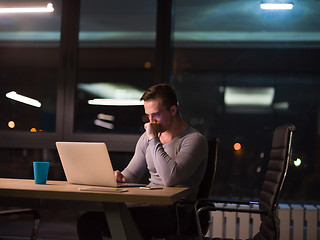 Image showing man working on laptop in dark office