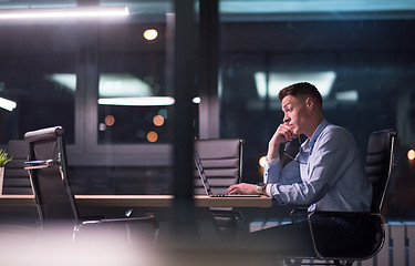 Image showing man working on laptop in dark office