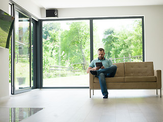 Image showing man on sofa using tablet computer