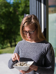 Image showing woman eating breakfast in front of her luxury home villa