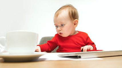 Image showing Happy child baby girl toddler sitting with keyboard of computer isolated on a white background