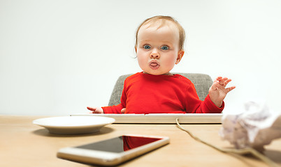 Image showing Happy child baby girl toddler sitting with keyboard of computer isolated on a white background