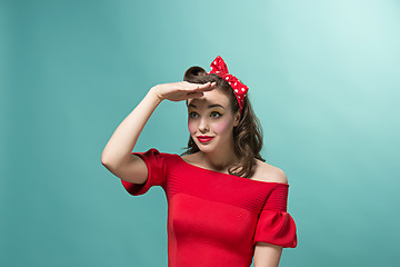 Image showing Beautiful young woman with pinup make-up and hairstyle. Studio shot on white background