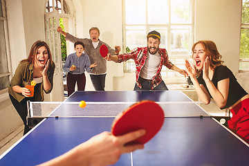 Image showing Group of happy young friends playing ping pong table tennis