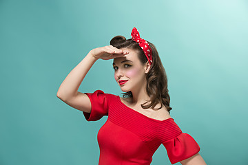 Image showing Beautiful young woman with pinup make-up and hairstyle. Studio shot on white background