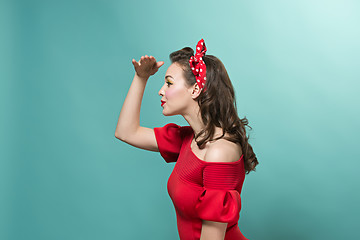 Image showing Beautiful young woman with pinup make-up and hairstyle. Studio shot on white background