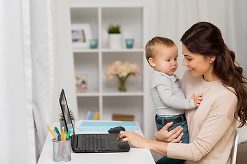 Image showing happy mother with baby and laptop working at home