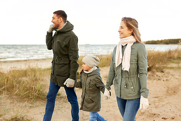 Image showing happy family walking along autumn beach