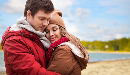 Image showing happy teenage couple hugging over autumn beach