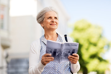 Image showing senior woman or tourist with city guide outdoors