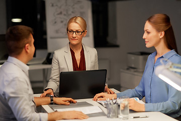 Image showing business team with laptop working at night office