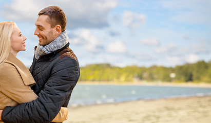 Image showing happy couple hugging over autumn beach