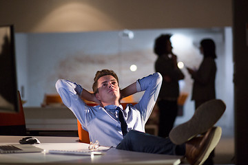 Image showing businessman sitting with legs on desk at office