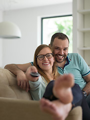 Image showing Young couple on the sofa watching television