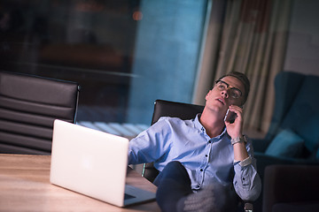 Image showing businessman using mobile phone in dark office