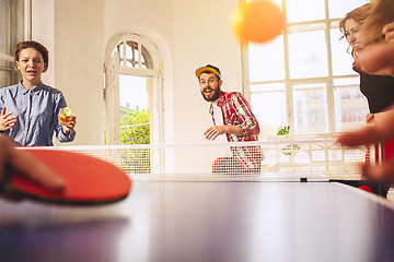 Image showing Group of happy young friends playing ping pong table tennis