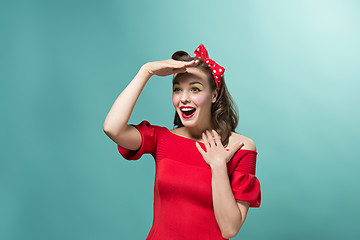 Image showing Beautiful young woman with pinup make-up and hairstyle. Studio shot on white background