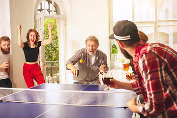 Image showing Group of happy young friends playing ping pong table tennis