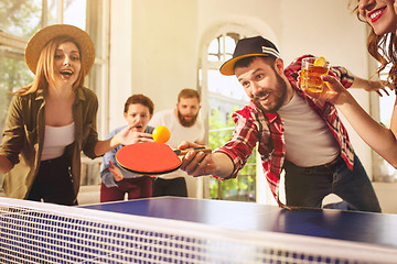 Image showing Group of happy young friends playing ping pong table tennis