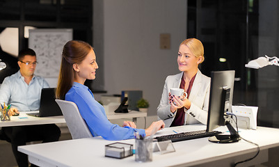 Image showing businesswomen drinking coffee at night office