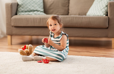 Image showing little girl playing with toy tea set at home