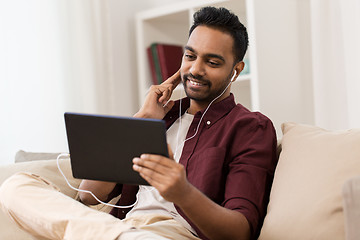 Image showing man in earphones with tablet pc listening to music