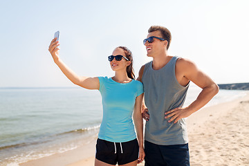 Image showing couple taking selfie by smartphone on beach