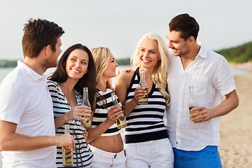 Image showing happy friends drinking non alcoholic beer on beach