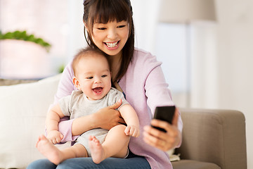 Image showing asian mother with baby son taking selfie at home