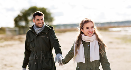 Image showing couple walking along autumn beach