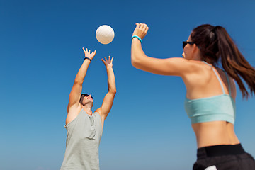 Image showing happy couple playing volleyball on summer beach
