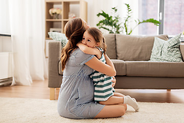 Image showing pregnant mother and daughter hugging at home