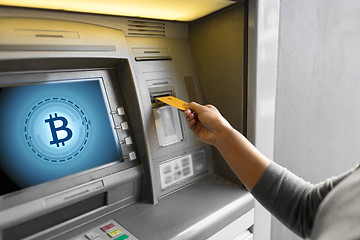 Image showing close up of woman inserting card to atm machine