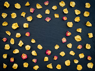 Image showing Rose petals heart frame on black background 