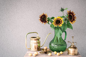 Image showing Bouquet of sunflowers and brass home decor