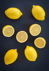 Image showing Whole and cut lemons on dark background